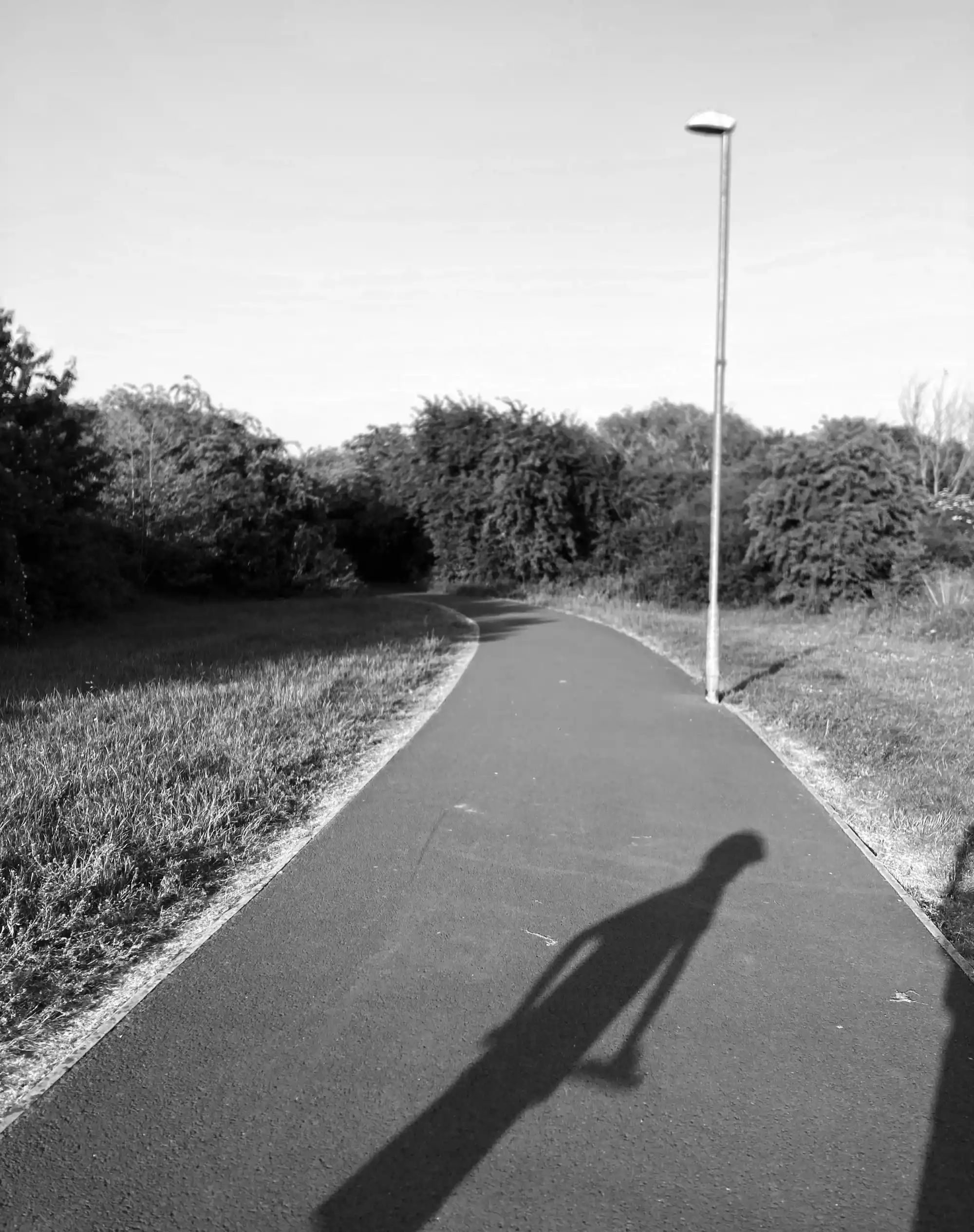 Black and white photo of a path with a child’s shadow in the foreground